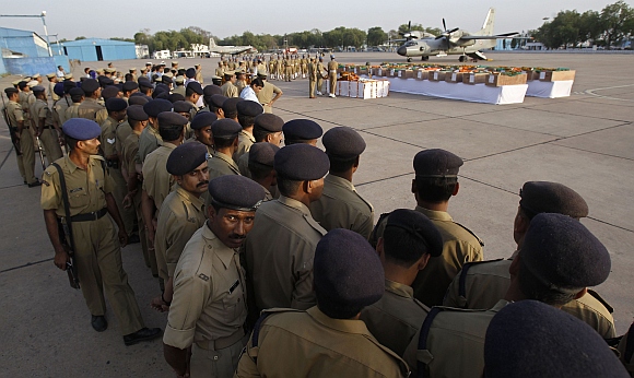 Central Reserve Police Force personnel wait for their turn to pay their respects near the coffins of colleagues who died in a Maoist attack in Chattisgarh