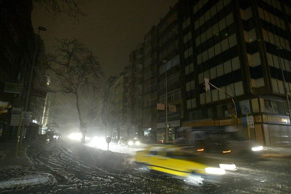 Motorists head home during a snow storm in a busy shopping district