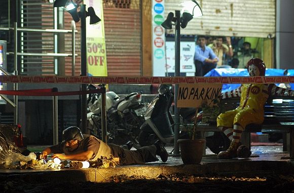 A policeman inspects the site of an explosion near McDonalds restaurant in Pune on Wednesday