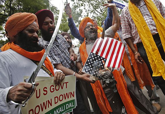 Activists from National Akali Dal, a regional Sikh political party, hold swords and shout slogans during a protest against Sunday's shooting at a Sikh temple in Wisconsin, US, in New Delhi