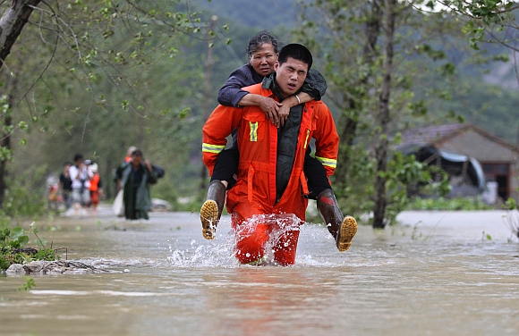 A rescuer carries a woman to a safer area in Taizhou, Zhejiang province