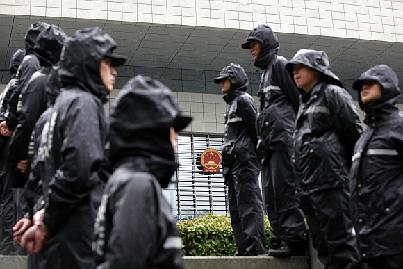 Police officers stand outside the Hefei Intermediate People's Court, where Gu Kailai's trial was held