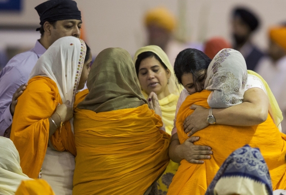 Family members and mourners gather during a wake and visitation service for victims of last Sunday's attack at a Sikh temple