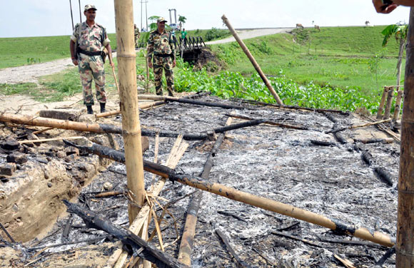 Army men monitor the scene of violence in Assam