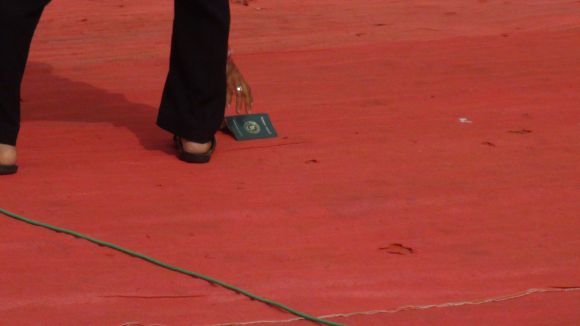 An MNS supporter picks up a Bangladeshi passport flung by Raj Thackeray while addressing a gathering at Azad Maidan