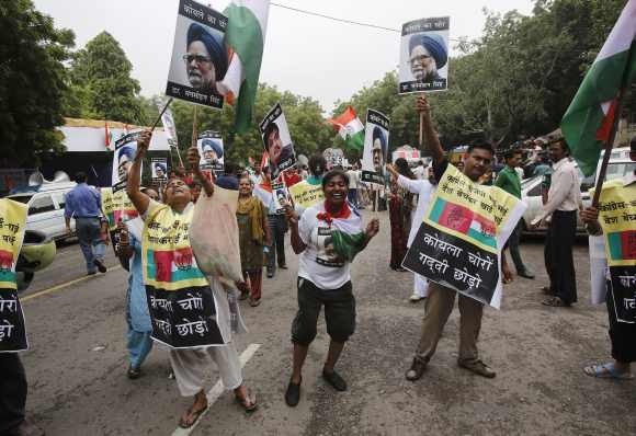 People shout slogans as they hold posters of Prime Minister Manmohan Singh during a protest against corruption in New Delhi