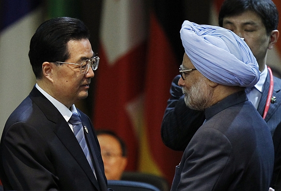 China's President Hu Jintao talks to Prime Minister Manmohan Singh at a plenary session during the Nuclear Security Summit at the Convention and Exhibition Center in Seoul