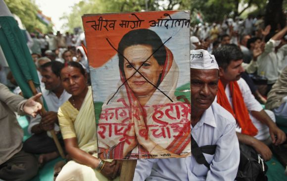 A supporter of social activist Anna Hazare holds up a poster of Congress chief Sonia Gandhi during an anti-corruption demonstration in New Delhi