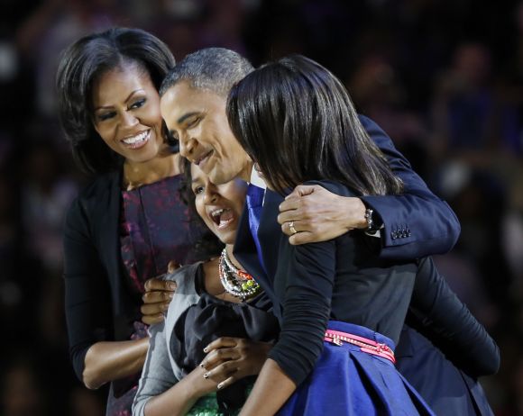US President Obama hugs his daughters at the victory rally in Chicago