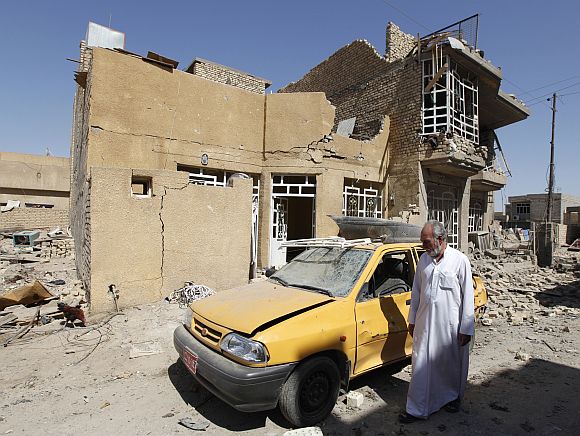A man walks near the site of a bomb attack in the town of Taji, about 20 km north of Baghdad