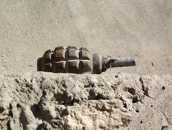 An unexploded grenade that police say was thrown by the Taliban lies on the edge of the blast wall at the Afghan Police camp in Musa Qal-Ah district in Helmand province, southwestern Afghanistan