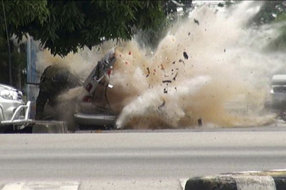 A car bomb explodes as a member of a Thai bomb squad checks it in Narathiwat province, south of Bangkok