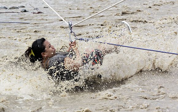 A typhoon victim clings on a rope while being evacuated in New Bataan town in Compostela Valley in southern Philippines December 6