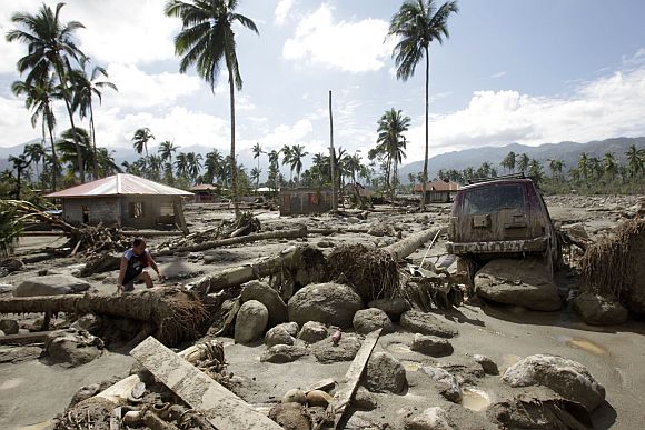 A man walks in an area swamped with debris and mud brought by Typhoon Bopha in New Bataan town in Compostela Valley in southern Philippines December 6