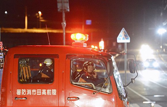 Firefighters persuade residents to evacuate after a strong earthquake hit the area in Rikuzentakata, Iwate prefecture, in this photo taken by Kyodo December 7