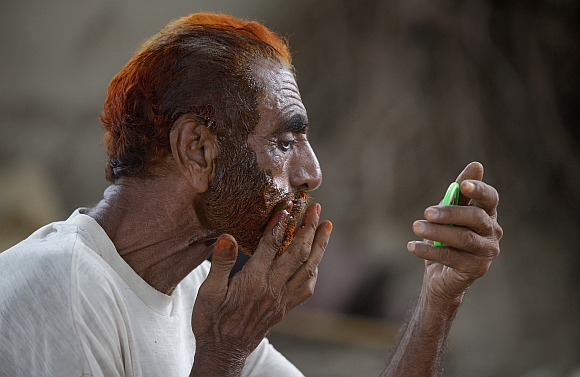A Muslim man applies henna dye on his beard and hair. According to the seminary, if the hair get red-like colour of henna, then it is permissible