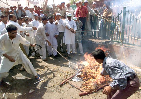 Muslims shout anti-government slogans as they burn an effigy of Narendra Modi