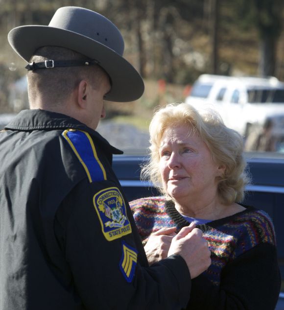 A woman speaks with a Connecticut State Trooper outside Sandy Hook Elementary School after a shooting in Newtown, Connecticut