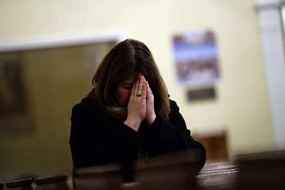 A woman prays at Saint Rose of Lima Roman Catholic Church near Sandy Hook Elementary School