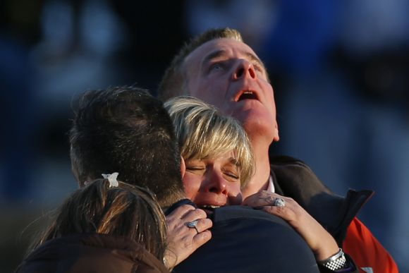 The families of victims grieve near Sandy Hook Elementary School, where a gunman opened fire on school children and staff in Newtown, Connecticut.