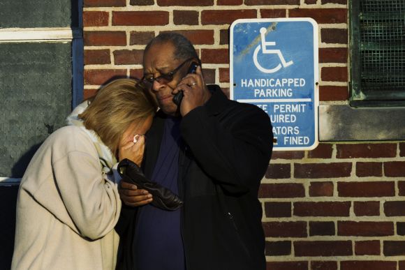 A woman leans on a man as she weeps outside a building set up to counsel family members affected by a shooting nearby at Sandy Hook Elementary School in Newtown, Connecticut.