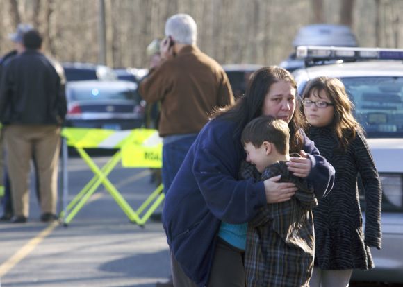 A young boy is comforted outside Sandy Hook Elementary School after a shooting in Newtown, Connecticut