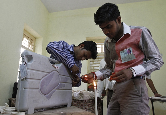 Polling officials seal an Electronic Voting Machine at Viramgam town in Gujarat