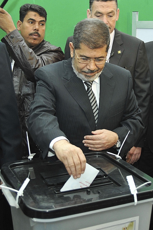 Egypt's President Mohamed Mursi casts his vote during a referendum on the new Egyptian constitution at a polling station in Cairo