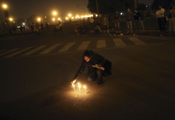 A demonstrator lights candles near the presidential palace during a protest rally in New Delhi