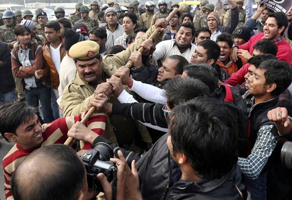 A policeman tries to stop demonstrators in front of the India Gate