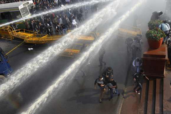 Demonstrators are hit by police water cannons near the presidential palace during a protest rally in New Delhi