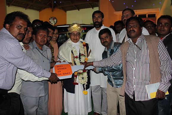 Former patients of the Sumanhalli Society present the keys to the Tata Nano to Sister Mary on her 75th birthday