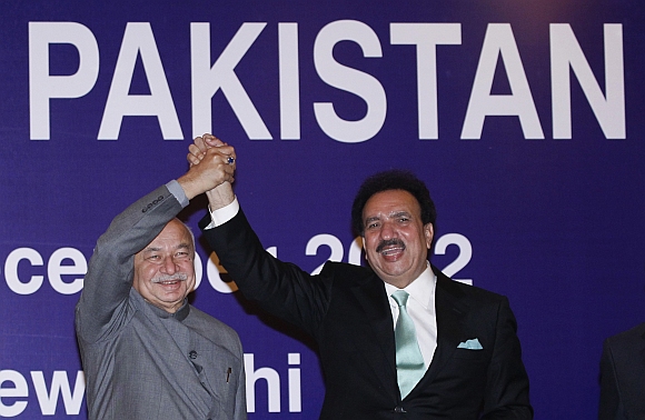 Pakistan's Interior Minister Rehman Malik and Indian Home Minister Sushil Kumar Shinde hold hands after the launch of a new visa agreement between India and Pakistan, in New Delhi