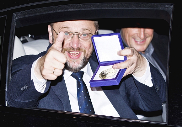 European Parliament President Martin Schulz displays the Nobel medal as he leaves Grand Hotel by car after the Nobel Peace Prize ceremony in Oslo