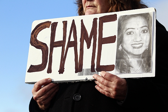 Mary Phelan holds a picture of Savita Halappanavar in protest outside University Hospital Galway in Galway, Ireland