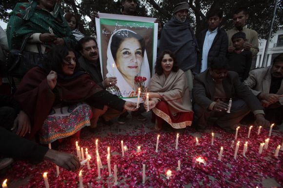Pakistan Peoples Party supporters light candles beside a poster of Pakistan's former prime minister Benazir Bhutto during her death anniversary in Lahore