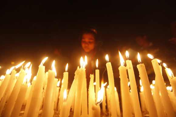 A girl lights candles during a candlelight vigil in Kolkata