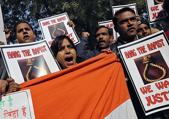 People shout slogans and hold placards during a protest in New Delhi