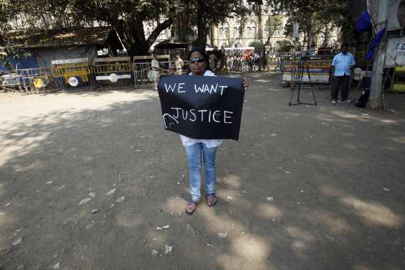 A protester holds a sign as she takes part in a demonstration to mourn the death of a rape victim, who was assaulted in New Delhi, in Mumbai