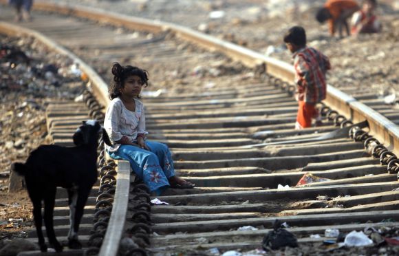 A girl sits on a rail track in a slum in Mumbai