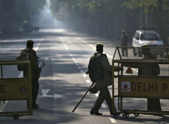A police officer pulls a barricade to close a road leading to India Gate in New Delhi