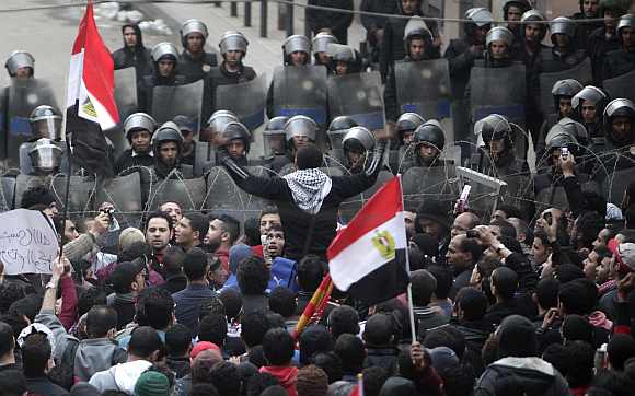 Riot police stand guard as soccer fans chant anti-ministry of interior slogans during a protest condemning the death that happened on Wednesday at Port Said stadium, near the Interior Ministry in Cairo, in front of the parliament in Cairo February 2