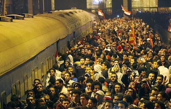 People gather around a train as they wait for the arrival of those wounded during clashes in Port Said stadium, at Ramses metro station in Cairo