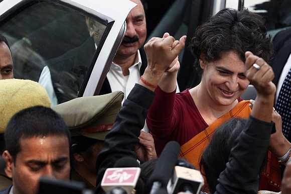 Priyanka Gandhi holds hands with Congress party supporters during a stopover in Rae Bareli district