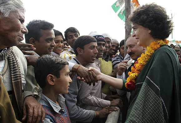 Priyanka Gandhi shakes hands with a supporter of the party during an election campaign rally at Amethi