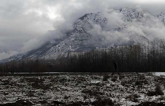 A man walks on a snow-covered track in Srinagar