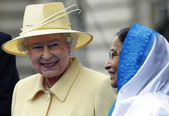 Queen Elizabeth II and President Pratibha Patil smile during a ceremonial baton handover to launch the Commonwealth Games