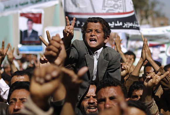 A boy shouts slogans with anti-government protesters as they march to demand the release of detained fellow protesters in Sanaa