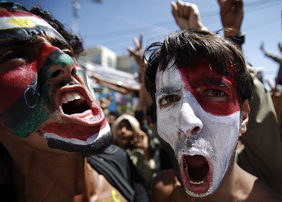 Anti-government protesters with their faces painted in colours of flags of Egypt, Tunisia, Kingdom of Libya and Yemen shout slogans during a rally to demand the ouster of Yemen's President Ali Abdullah Saleh in Sanaa