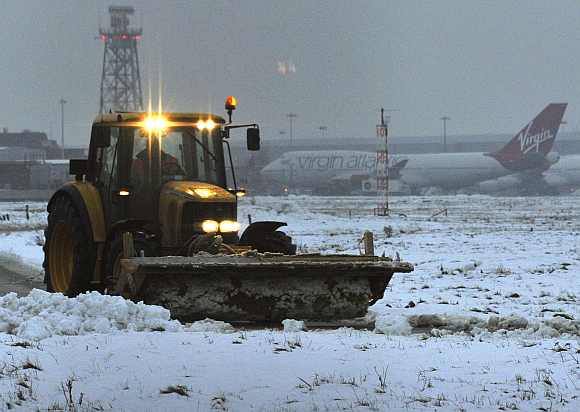 Snow is cleared from the southern runway at Heathrow airport in west London